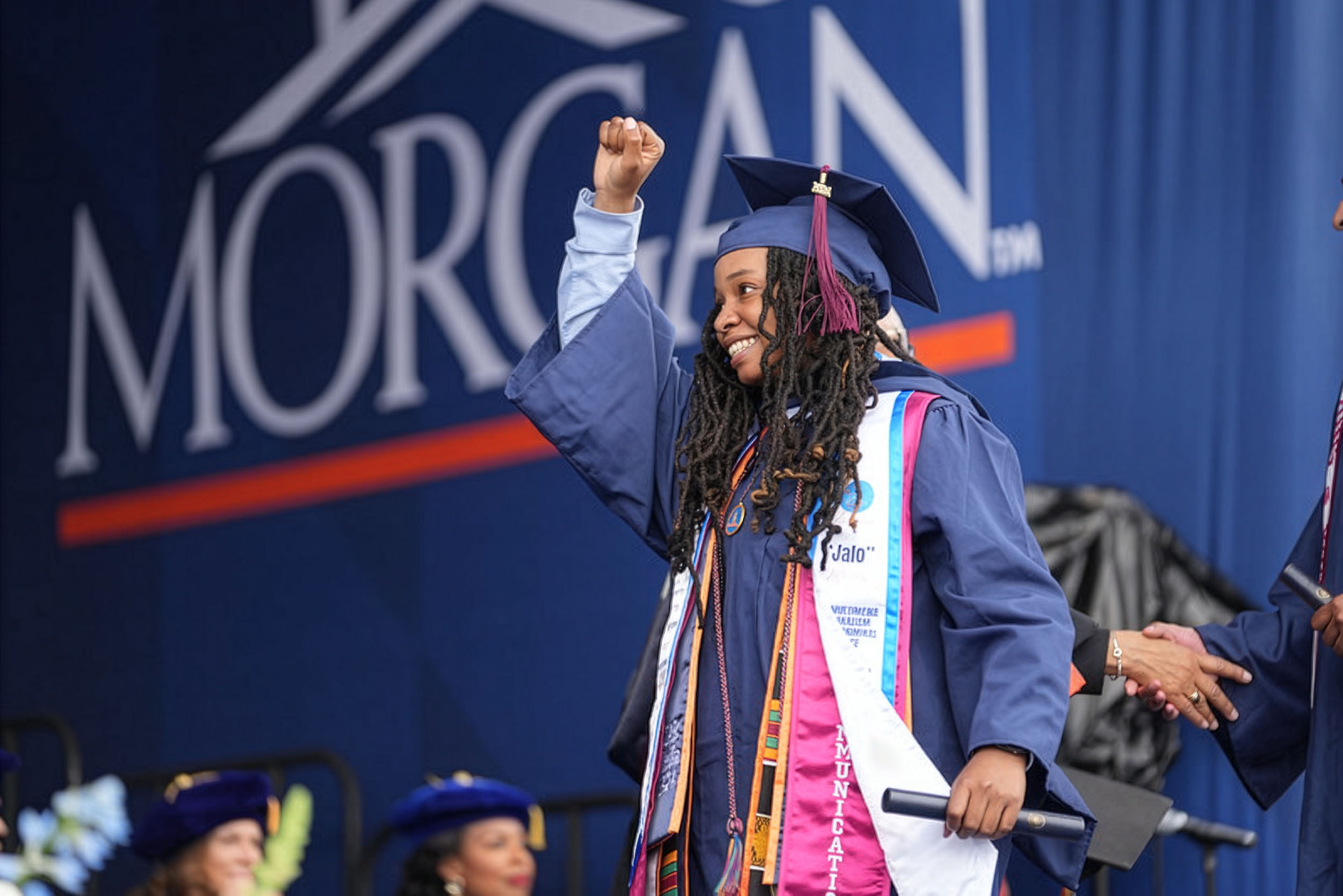 graduating female student walking across the stage