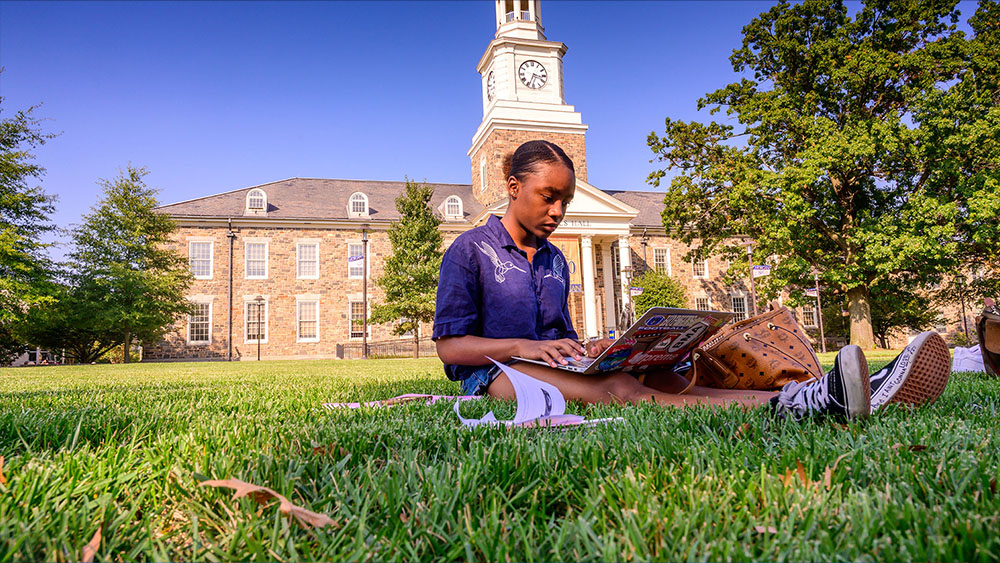 female student sitting on the quad lawn